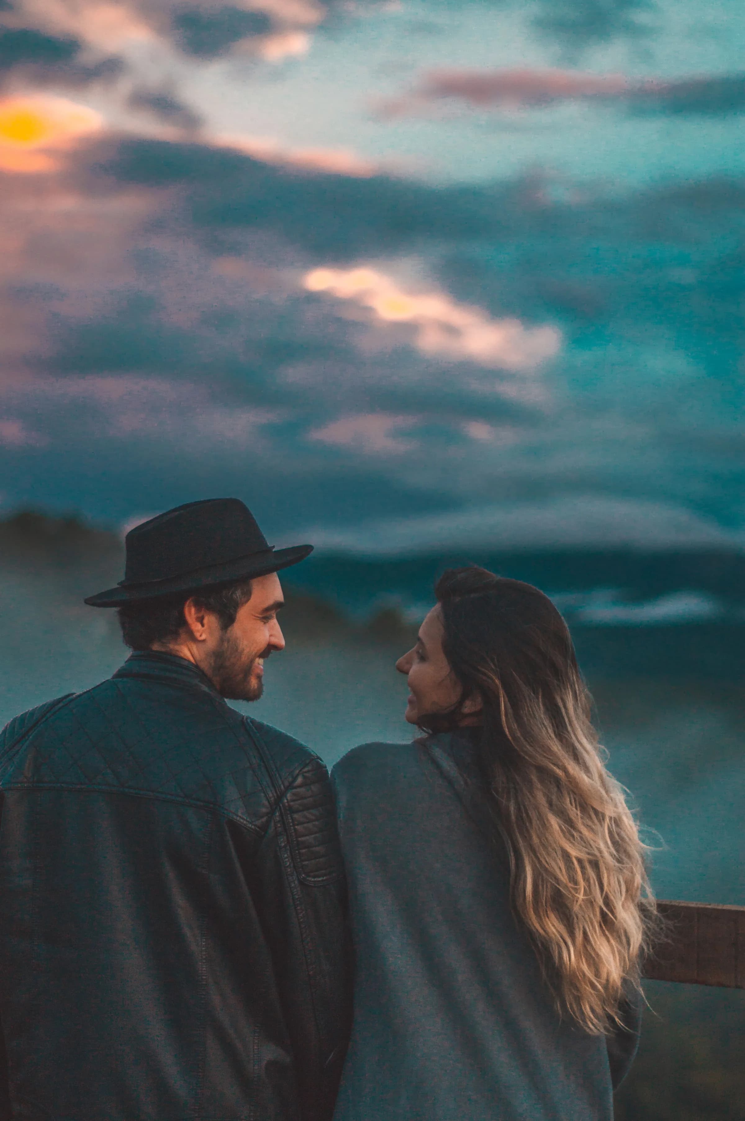 Couple smiling at each other outdoors at sunset